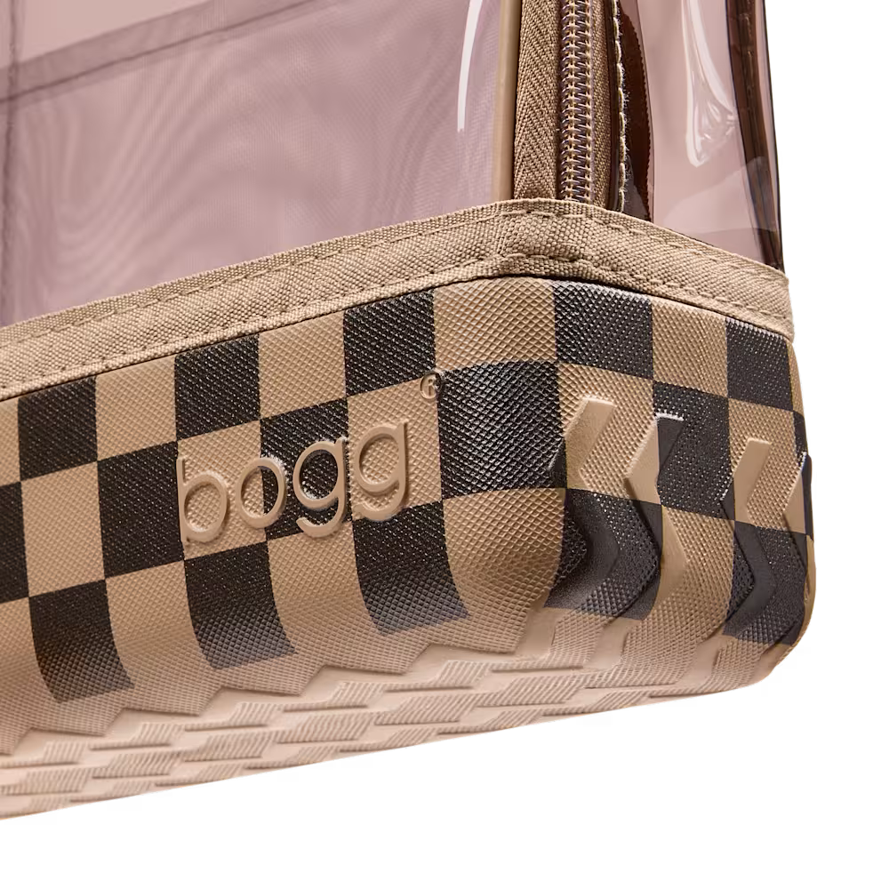 Close-up of a clear plastic zip pouch with a beige and black checkerboard patterned base and embossed BOGG branding.