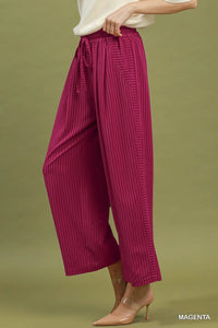 Magenta wide-leg pants worn by a person on a green background