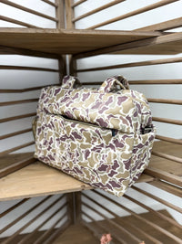Camouflage-patterned bag on a wooden shelf