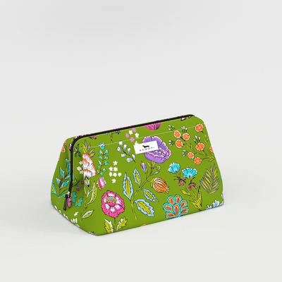 A green cosmetic pouch with a colorful floral and botanical print, featuring a small white brand label on the front, set against a plain light gray background.