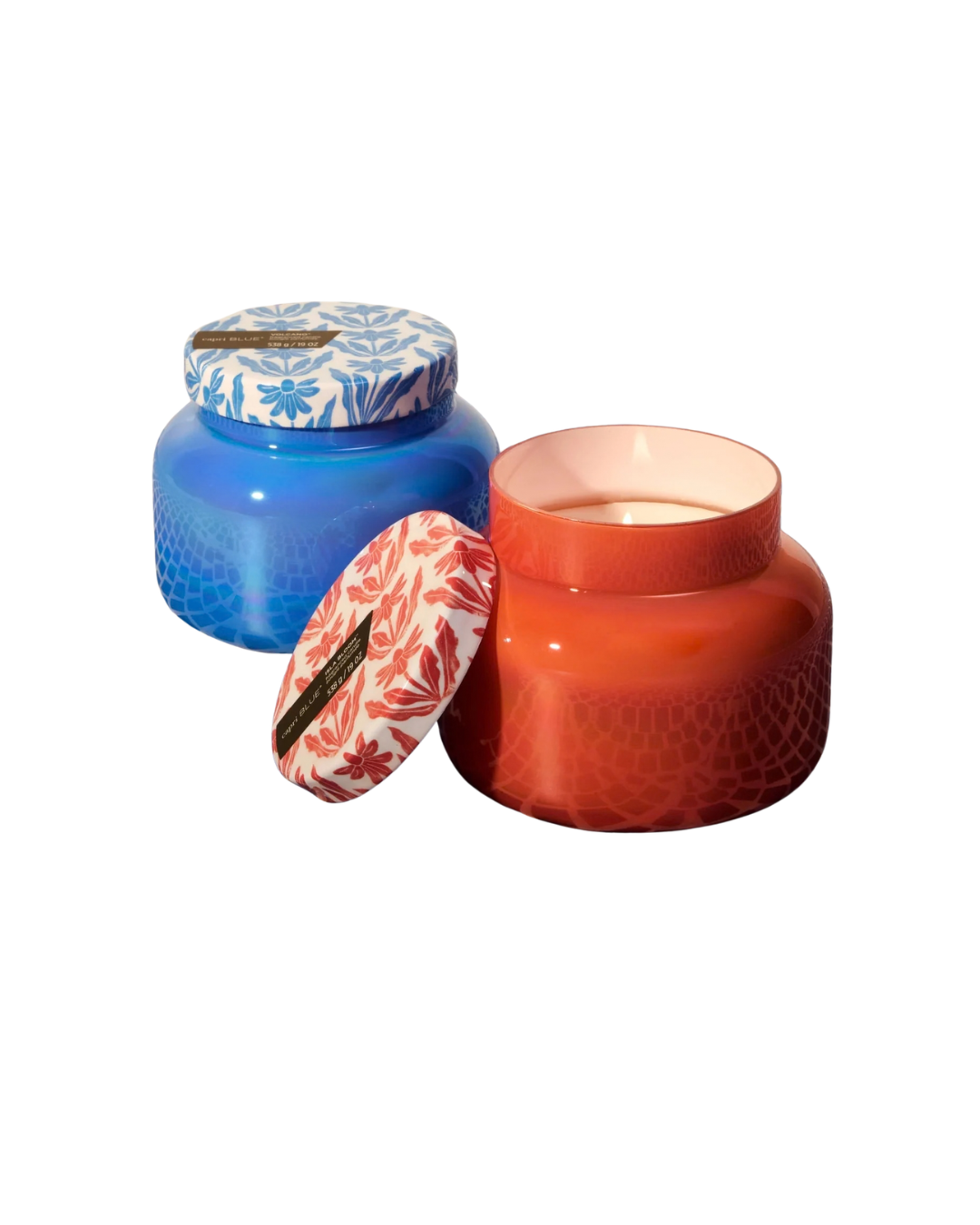 Two decorative candles with patterned lids on a white background