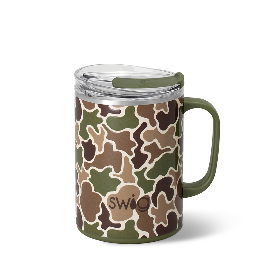 A handled insulated travel mug with a clear lid, featuring an all-over camouflage pattern in olive green, brown, tan, and dark brown. The brand name 'swig' is printed in brown near the bottom center.